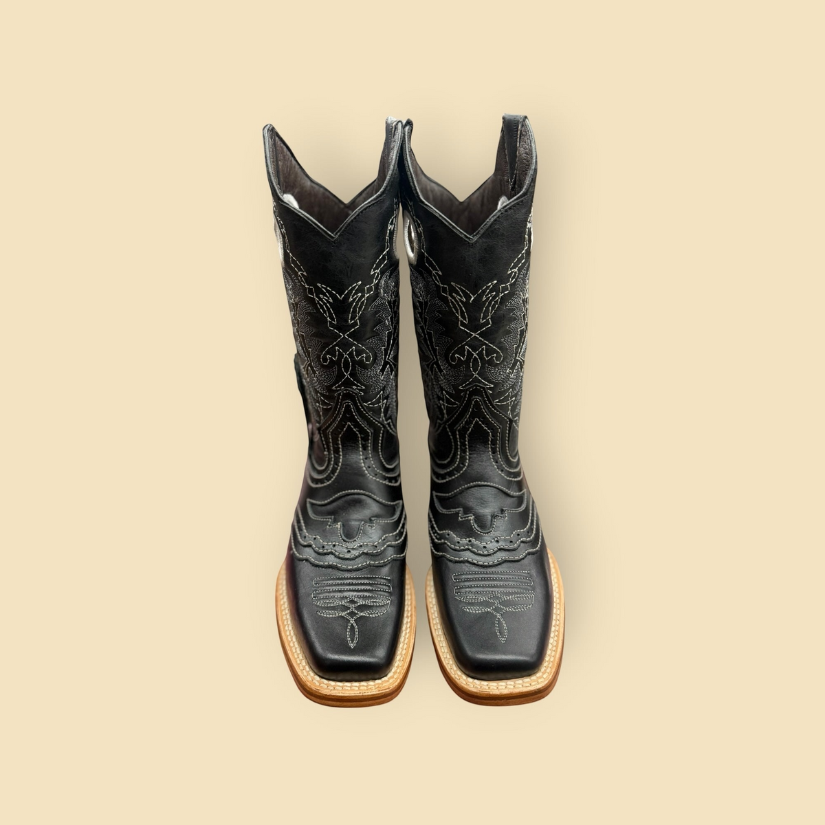 Lopez Fashion black leather cowboy boots with square toe and intricate white contrast stitching on a neutral background