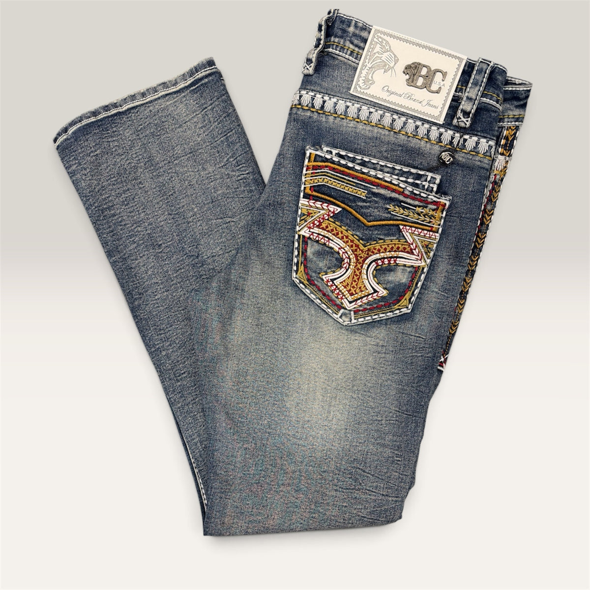 Lopez Fashion medium-wash denim jeans featuring intricate multi-colored embroidery on back pockets and side seams.
