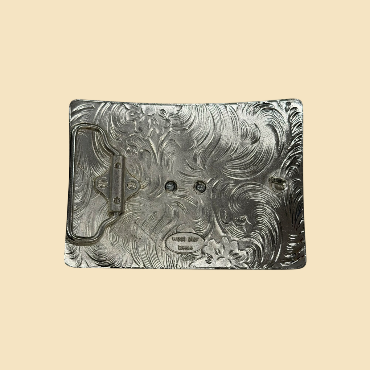 Lopez Fashion silver-tone belt buckle back with intricate floral scrollwork and West Star Texas branding